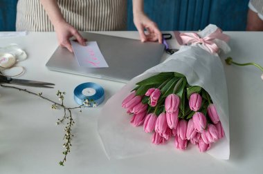 Takım çalışması. İki güzel çiçekçi bir buket oluşturuyor.