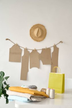 Çizimlerin arka planında kumaş ve iplikler olan tablo