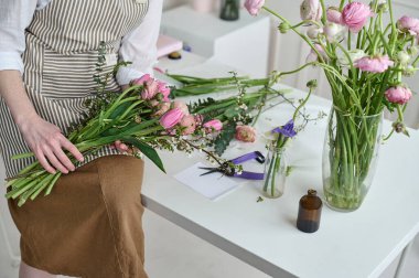 Çiçekçide elinde buketle yaratıcı bir kadın. Çiçekçilik işinin başlangıcı..