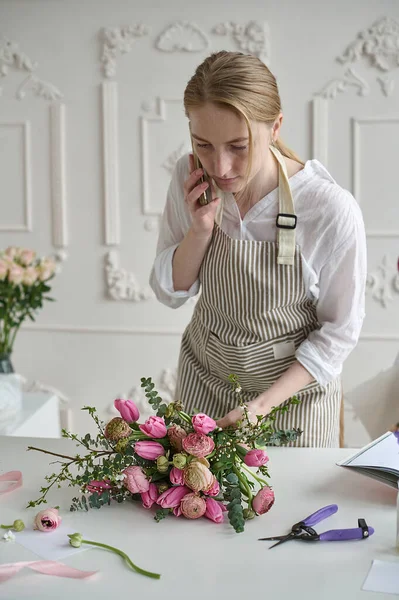Dizüstü bilgisayar kullanan genç yaratıcı kadın bir çiçek dükkanında. Çiçekçi iş başlangıç.