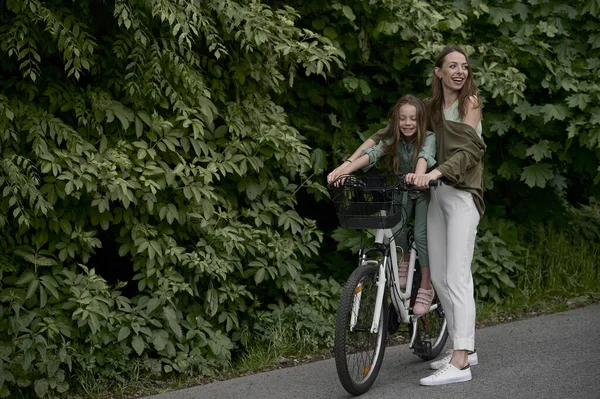妈妈和女儿在公园里骑车 儿童暑假概念 — 图库照片