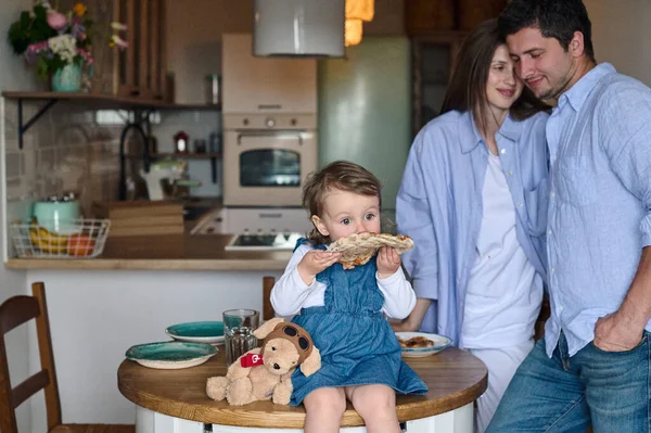 ママとパパと娘は台所で一緒に食事をする 幸せな家庭のコンセプト — ストック写真