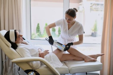 Beautiful woman enjoys buttocks massage with machine for anti-cellulite and body correction