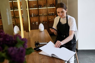Küçük bir güzellik salonundaki kadın stilistin ya da iş sahibinin portresi.