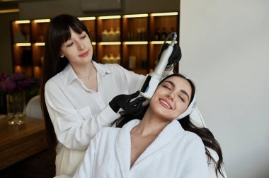 Beautiful woman enjoys buttocks massage with  machine for anti-cellulite and body correction