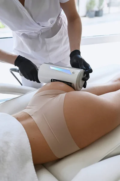 Beautiful woman enjoys buttocks massage with endosphere machine for anti-cellulite and body correction