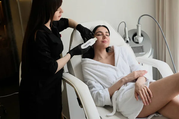 Face peeling mask, spa beauty treatment, skincare. Woman getting facial care by beautician at spa salon