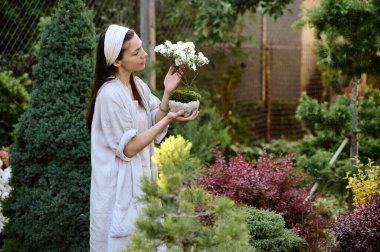 Bonsai bahçesindeki bir bonsai ağacında kalan genç bir kadın.