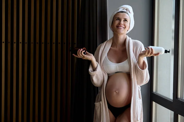 Retrato Uma Bela Mulher Grávida Roupão Toalha Aplica Creme Barriga — Fotografia de Stock