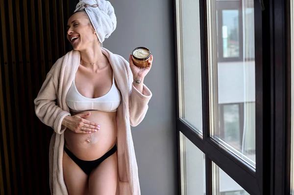 Beautiful Pregnant Woman Bathrobe Applies Cream Her Belly Window Morning — Fotografia de Stock