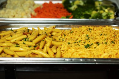 Metal tepside servis edilen lezzetli ev yapımı fırında patatesler. Çeşitli otlar, tereyağı, sarımsak ve tuzla. Gri taş arka plan. Yukarıdan görüntüle..
