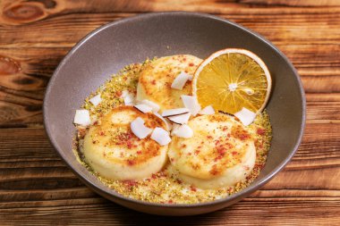 Portakallı ve hindistan cevizli süzme peynirli börek veya Syrniki. Ukrayna, Rus yemekleri.