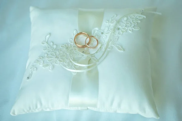 Wedding rings made of white gold lie on pink pillow — Stock Photo, Image