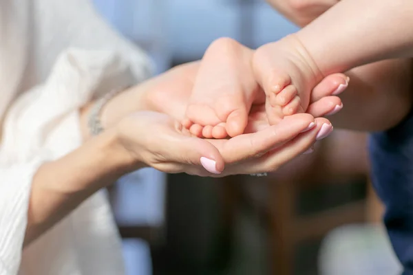 Mothers hand covering her babys feet — Stock Photo, Image