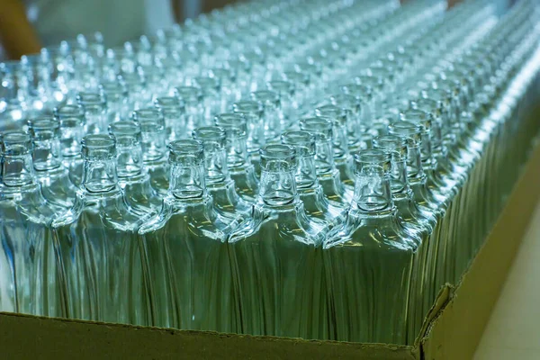 Lege glazen flessen op de transportband. Fabriek voor het bottelen van alcoholhoudende dranken. Productie en botteling van alcoholhoudende dranken. — Stockfoto