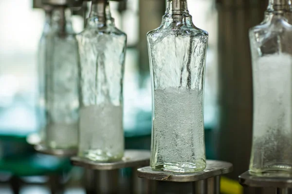 Пляшки з напоєм закриті гвинтовою кришкою. Завод з виробництва алкогольних напоїв — стокове фото