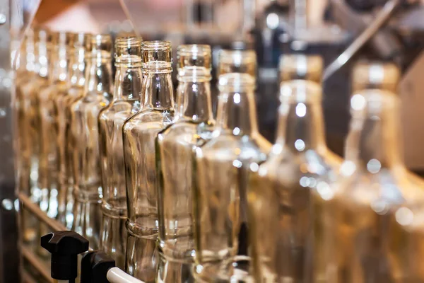 Üres üveg palackok a szállítószalag. Gyári alkoholtartalmú italok palackozás. Termelés és az alkoholtartalmú italok palackozás. — Stock Fotó