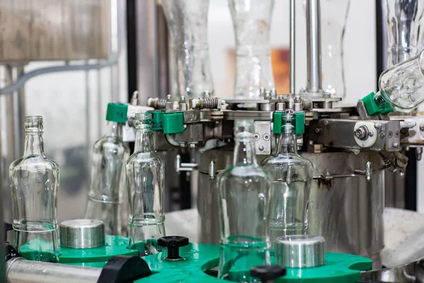La máquina para lavar botellas de vidrio. Fábrica de embotellado de bebidas alcohólicas . —  Fotos de Stock