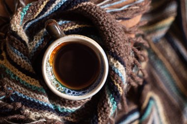 Bir fincan kahve ve sıcak yün atkı.