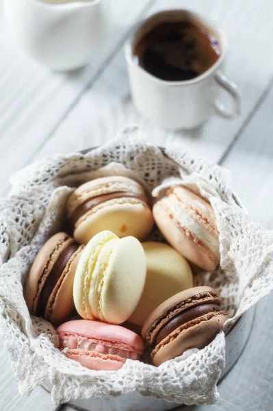 Macarons multicoloridos em uma chapa e café — Fotografia de Stock