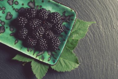Yeşil tabakta yapraklı taze böğürtlen