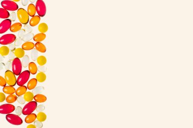 Vitamin veya ilaç içeren çok renkli şeffaf kapsüller ve sağdaki metin için yer