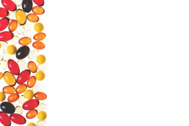 Beyaz üzerine izole edilmiş vitamin veya ilaç içeren çok renkli şeffaf kapsüller ve sağdaki metin için yer