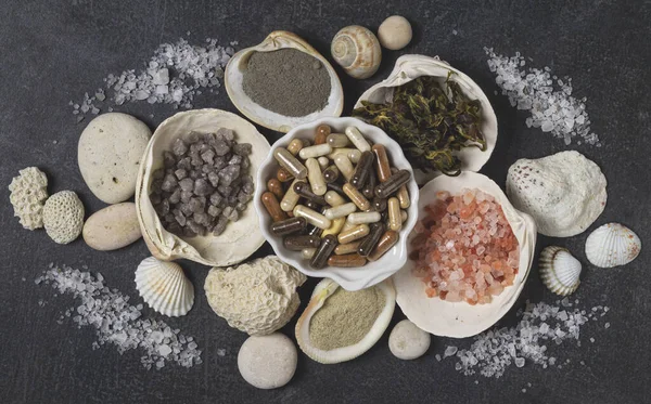 Dietary supplements in capsules, various crystals of salt, algae and sea minerals in plates — Stock Photo, Image