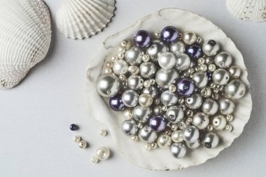 Büyük bir kabukta çeşitli inci boncuklar.