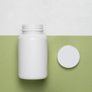Yeşil arka planda kapağı olan boş plastik kavanoz