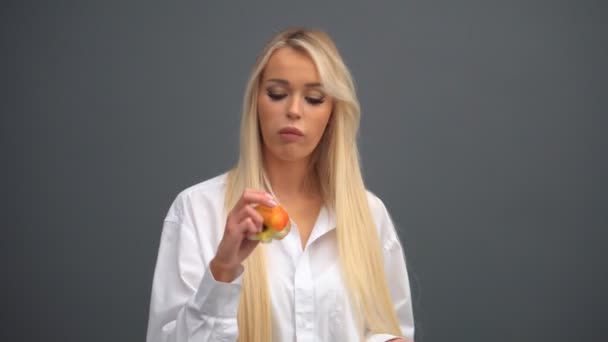 Bir kız stüdyoda elmalarla poz veriyor. — Stok video