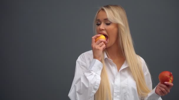 Uma menina posa com maçãs no estúdio — Vídeo de Stock