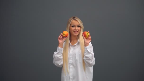 Una chica posa con manzanas en el estudio — Vídeo de stock