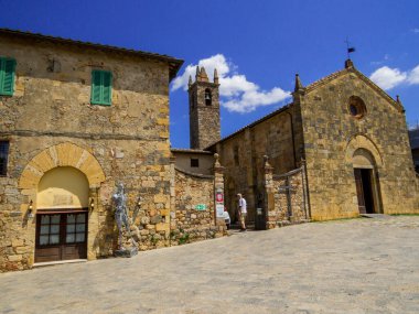 Monteriggioni, İtalya - 29 Temmuz 2022: Saint Mary Kilisesi ile ana meydanın manzarası.