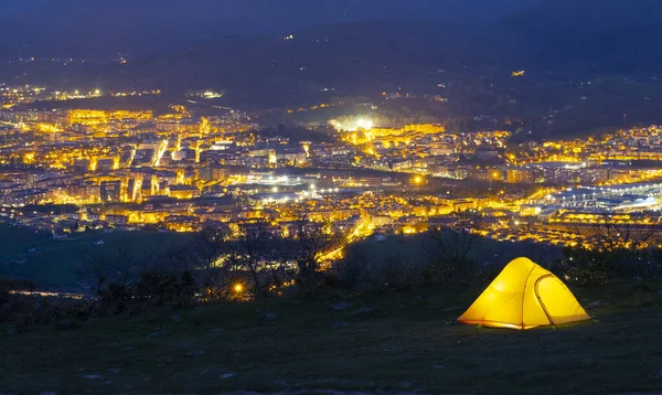 背景に街の灯りがともる夜のテントキャンプ エウスカディのイラン — ストック写真