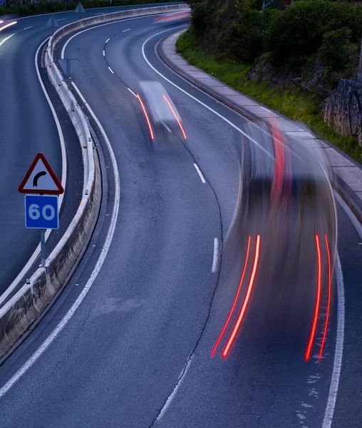 Car lights at night on road curves