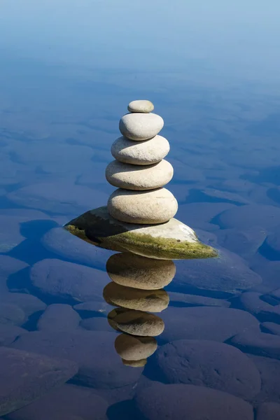set of stones in equilibrium reflected in the sea, concept of stability and harmony.
