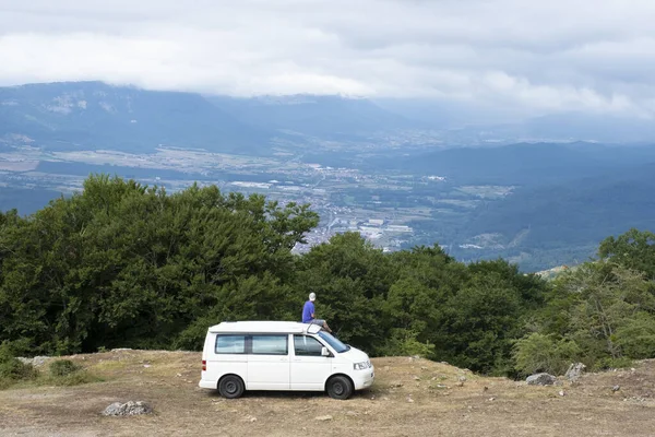 man on a van looking out over the landscape