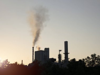 Industrial area, thick smoke. Climate change and global warming. Pollution produced by a factory, gases coming out of a chimney.