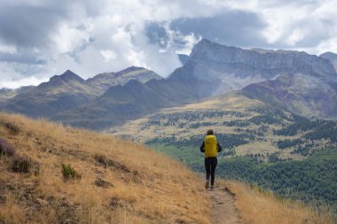 Girl with backpack hiking in the Natural Park of the Western Valleys , Huesca