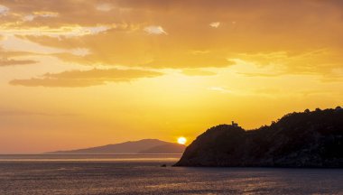 Güneş şafak vakti Getaria 'daki dağlardan yükseliyor ve Bask ülkesinin kıyılarındaki Cantabrian Denizi' nden..