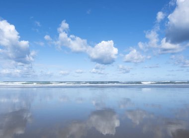 Gökyüzündeki bulutlar denize ve sahile yansıyor..