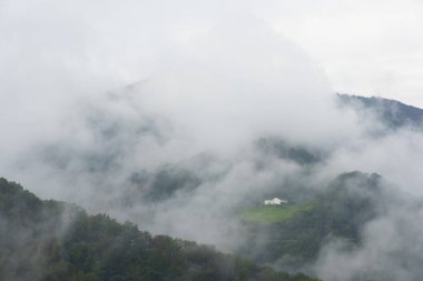 Dağlar arasındaki evde bulutlu ve yağmurlu bir gün.