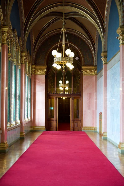 BUDAPEST, HONGRIE - 03 MAR 2019 : Long couloir avec tapis rouge au sol en marbre et lustre au plafond dans le bâtiment du Parlement hongrois — Photo