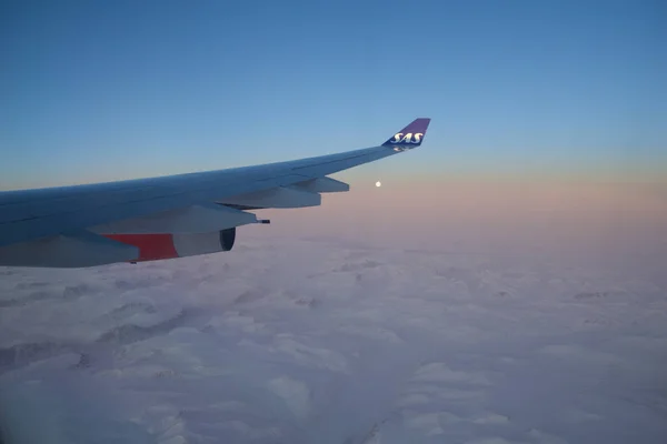 KOPENHAGEN, DINAMARCA - 24 NOV 2018: Vista da cabine da aeronave para a asa ao pôr do sol sobre os icebergs da Gronelândia — Fotografia de Stock