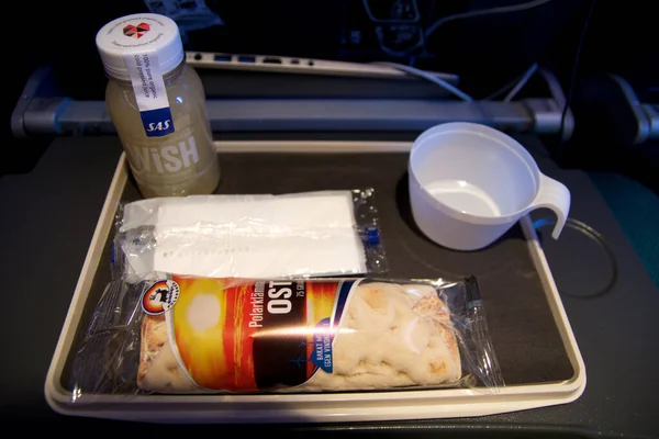 STOCKHOLM, SWEDEN - 24 NOV 2018: Inflight snack on an economy class flight. Plane meal consisting of smoothie and wrap — стоковое фото