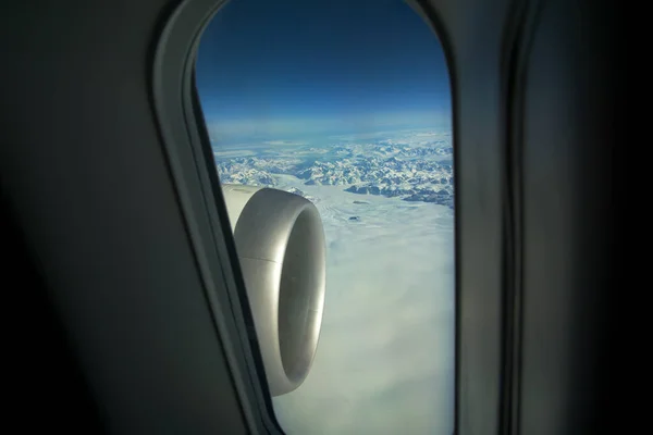 GREENLAND - 10 MAY 2018: View from the large plane window of a modern aircraft of the jet engine and the icy landscape of Greenland in the background — Stockfoto