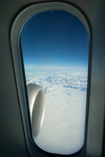 GREENLAND - 10 MAY 2018: View from the large plane window of a modern aircraft of the jet engine and the icy landscape of Greenland in the background — Stock Photo, Image