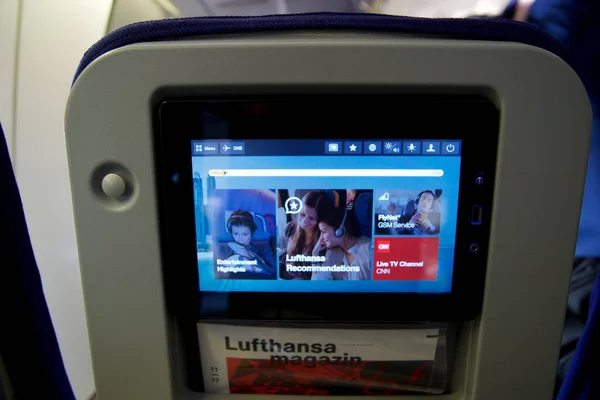 FRANKFURT, GERMANY - 03 NOV 2017: In-flight entertainment screen on a long-haul flight in Economy Class Лицензионные Стоковые Изображения