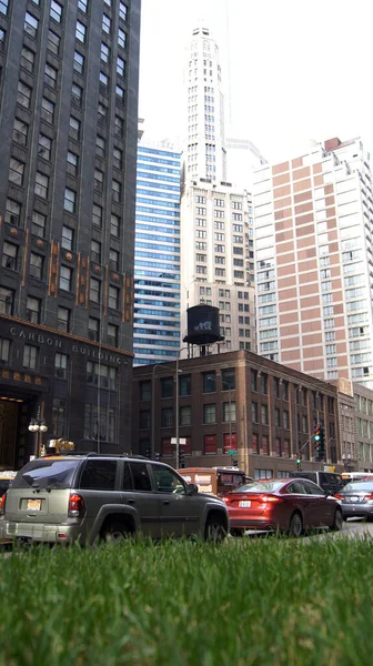 CHICAGO, ILLINOIS, ESTADOS UNIDOS - DIC 11, 2015: Cañones urbanos entre rascacielos del centro, con coches en primer plano —  Fotos de Stock